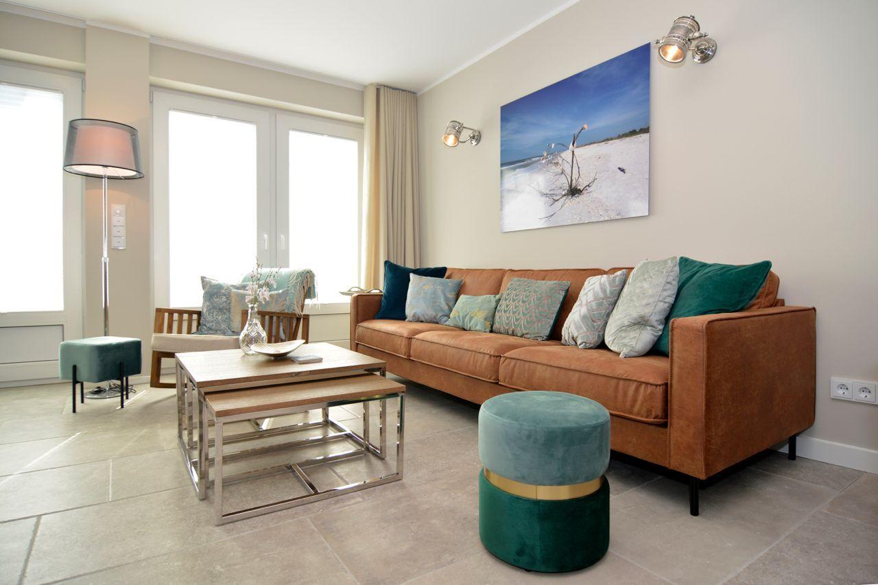 A living room with brown sofa, green cushions, and wooden table.
