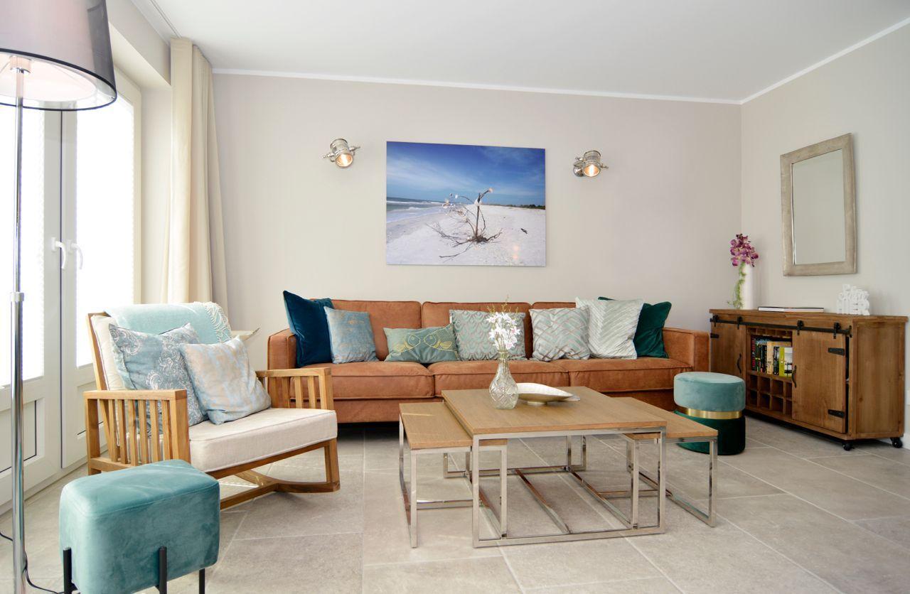 Living room with sofa, armchair, and coffee table. Wall art and mirror are visible.