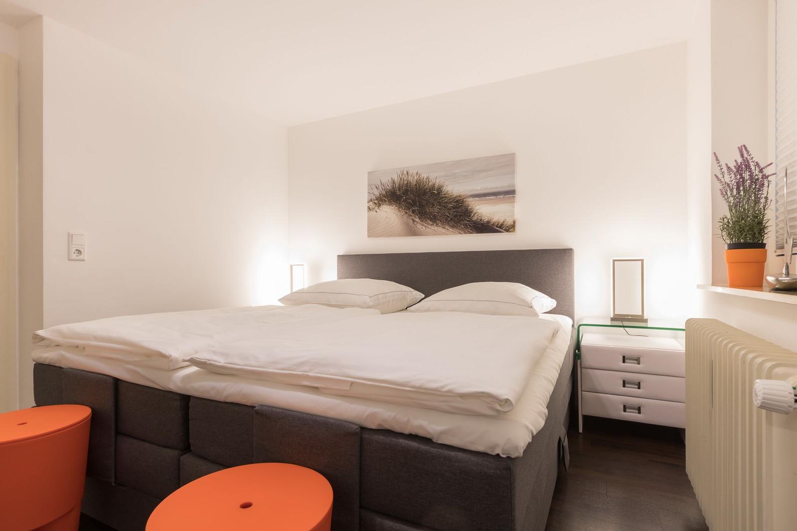 Bedroom with bed, nightstand, and wall art.