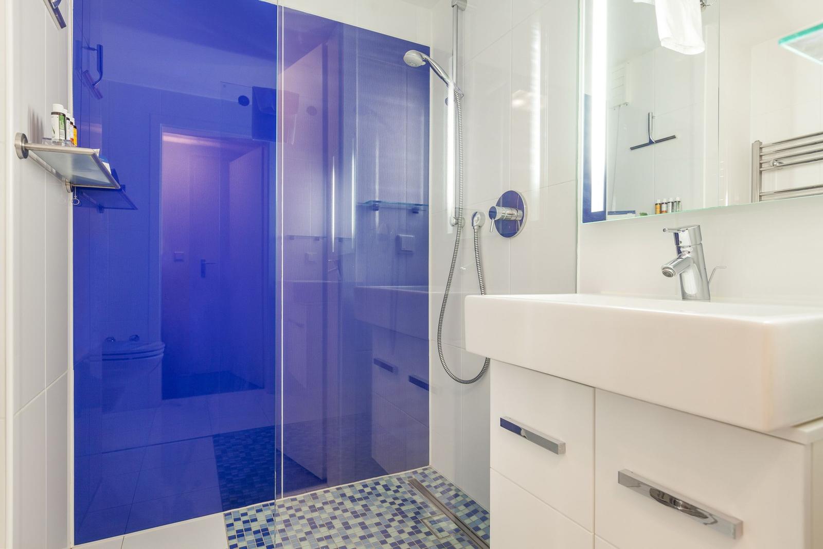 Bathroom with shower, sink, and mirror