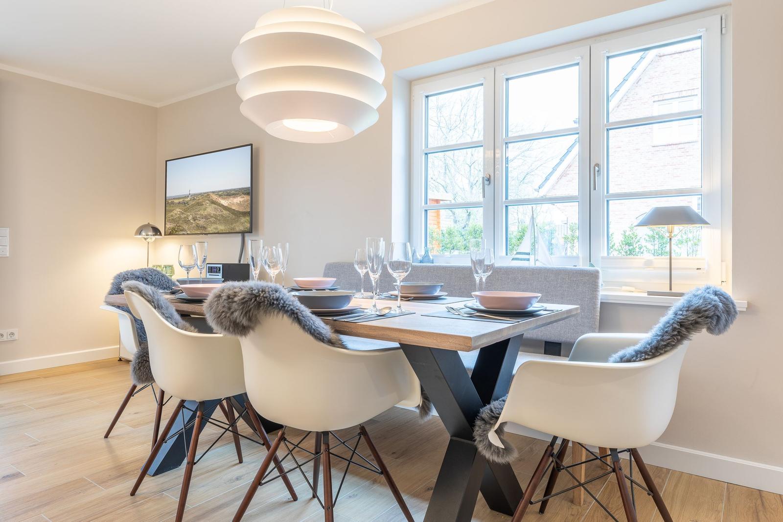 Dining room with table, chairs, and windows.