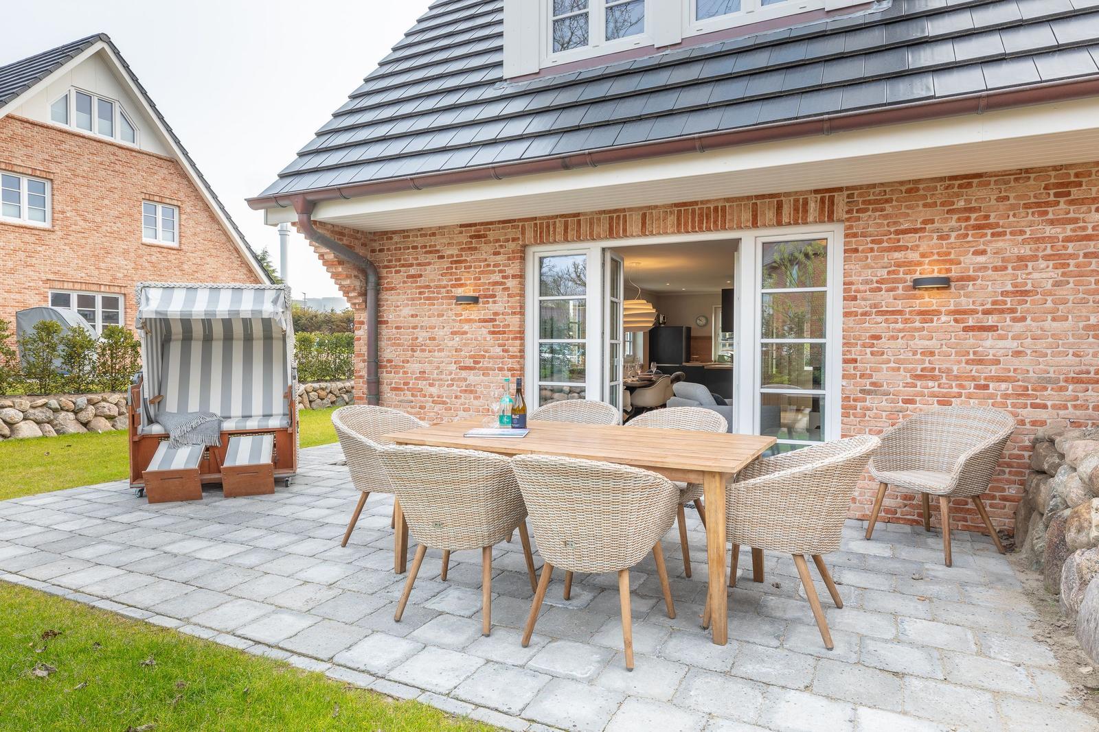 Terrace with dining table, chairs, and beach chair. View into the kitchen.