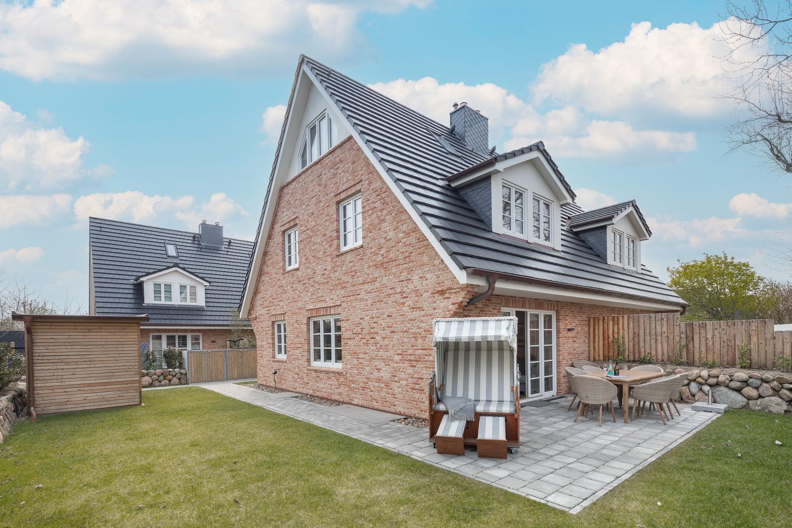 House with terrace, garden, and sun lounger. Backyard with wooden shed.