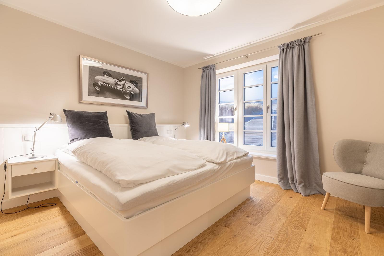 Bedroom with double bed, window and armchair.