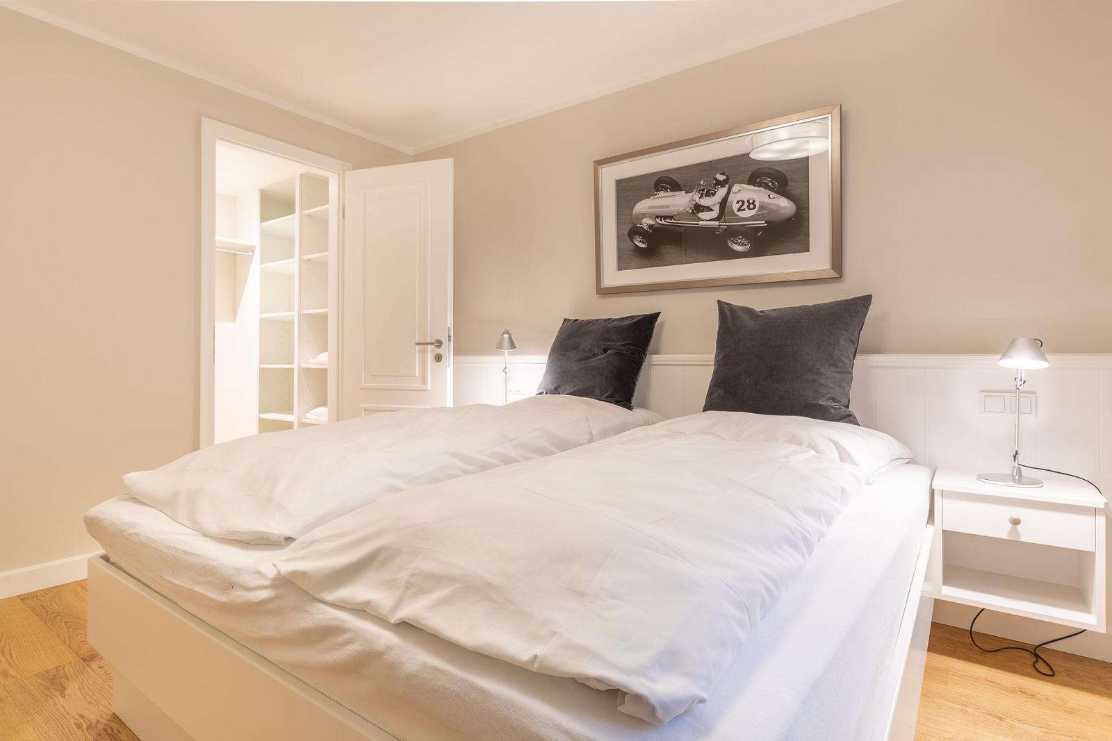 Bedroom with double bed, nightstand, and picture on the wall.