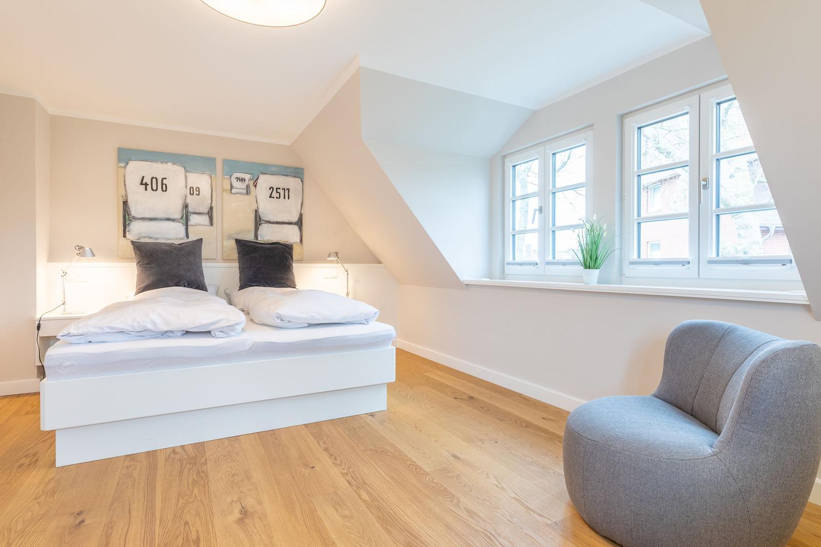 Bedroom with double bed, windows, and armchair