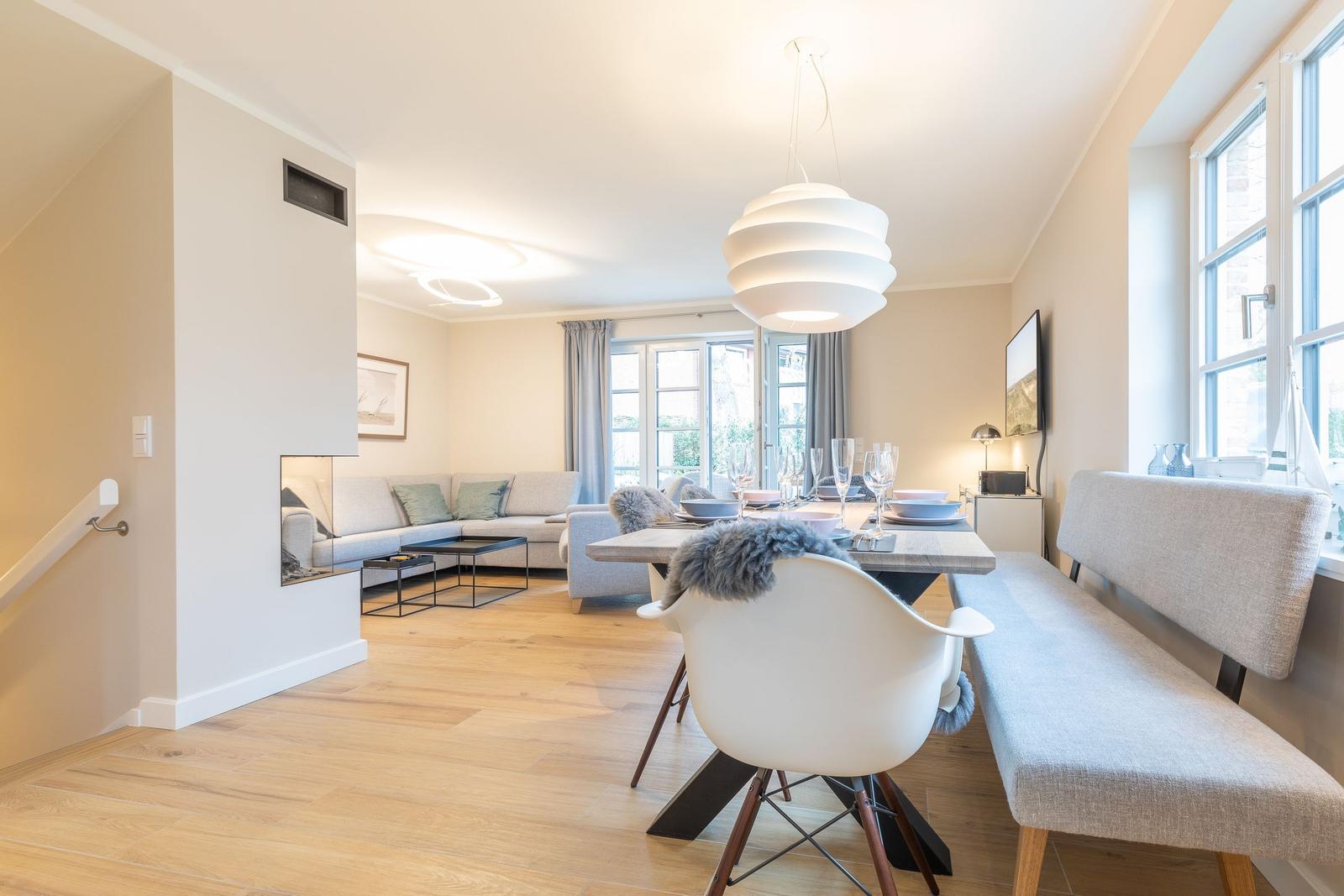 Dining area with table, chairs, and windows. Living area with sofa and floor heating.