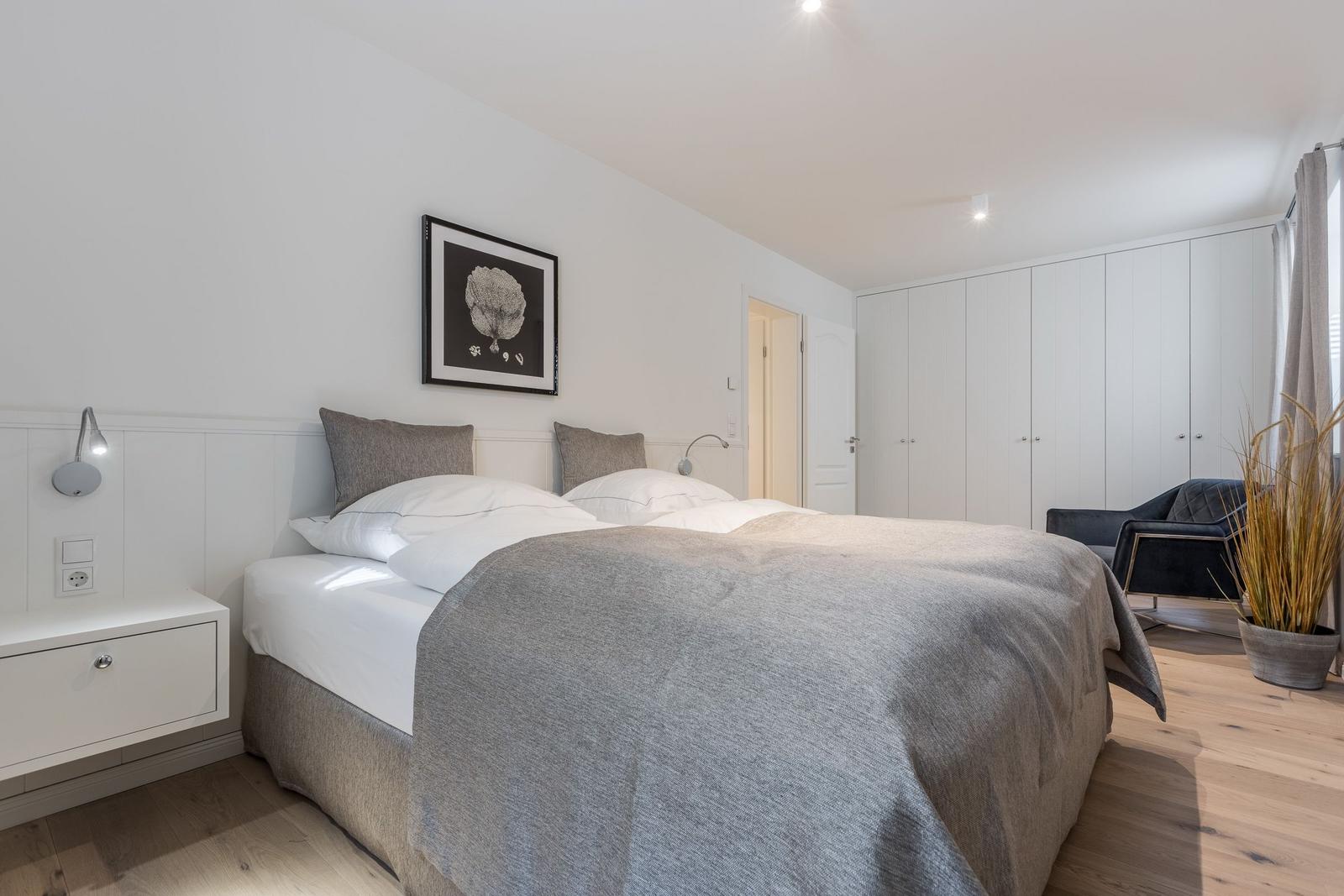 Schlafzimmer mit Doppelbett, Nachttisch und Kleiderschrank.