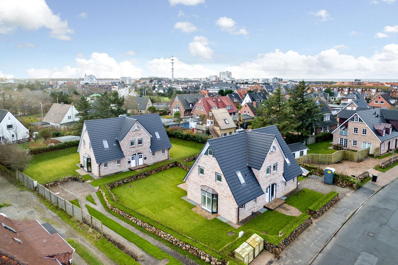 Zwei Häuser mit Gärten und Blick auf die Stadt.