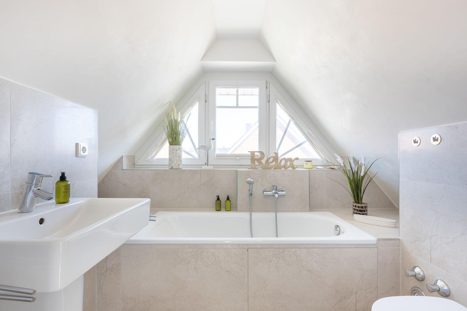 Bathroom with bathtub, sink, and skylight