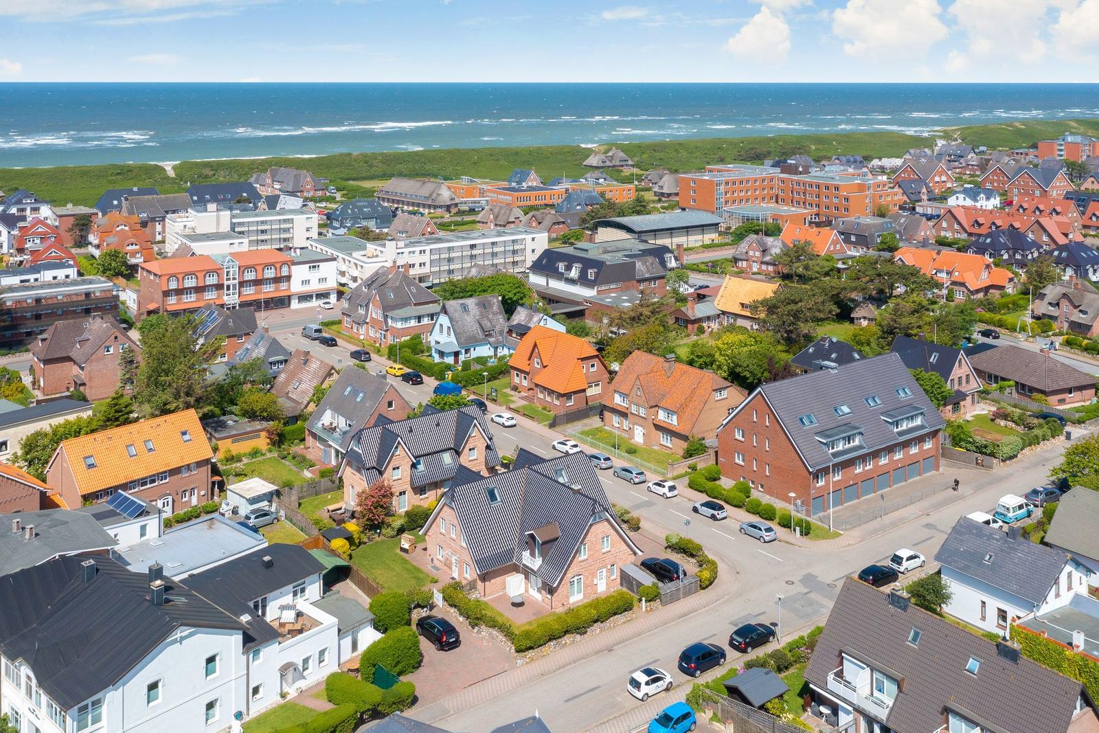 Houses and streets by the coast with a view of the sea.