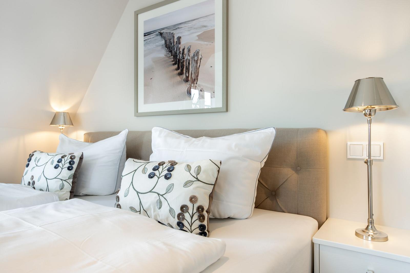 Doppelbett mit Kissen und Bild an der Wand
