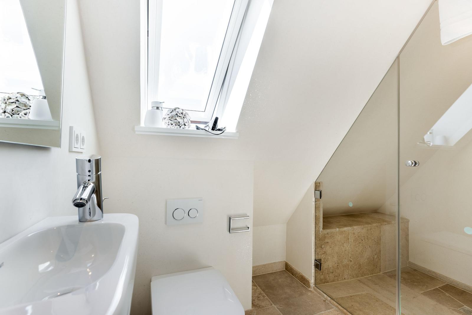Badezimmer mit Dusche, Waschbecken und Dachfenster