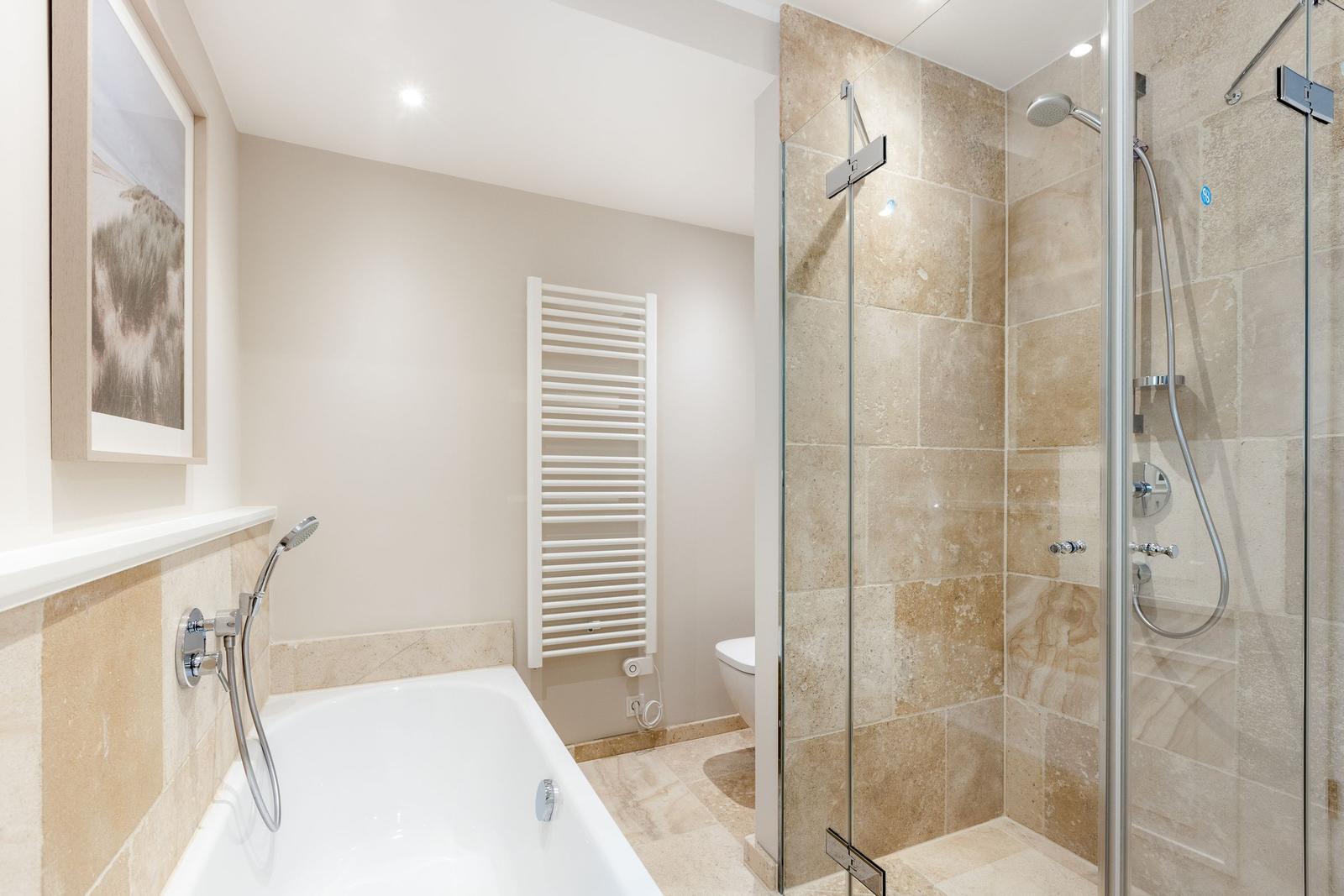 Badezimmer mit Badewanne, Dusche und Toilette.