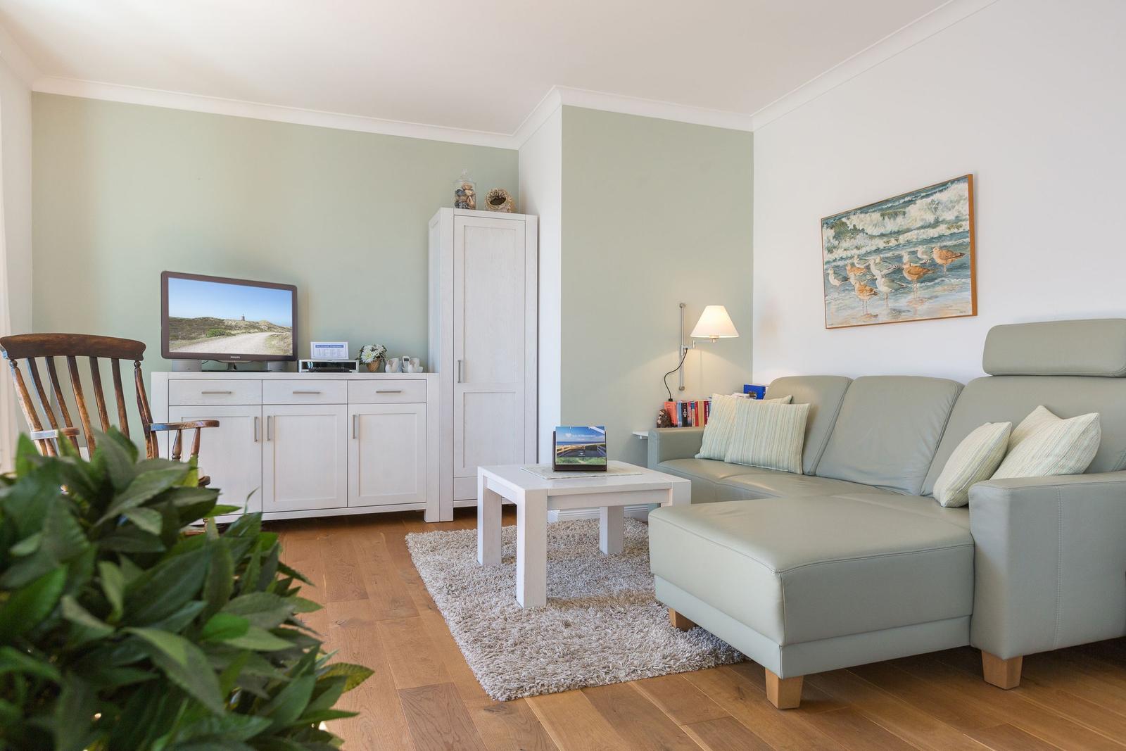 Wohnzimmer mit Sofa, Couchtisch und Fernseher.