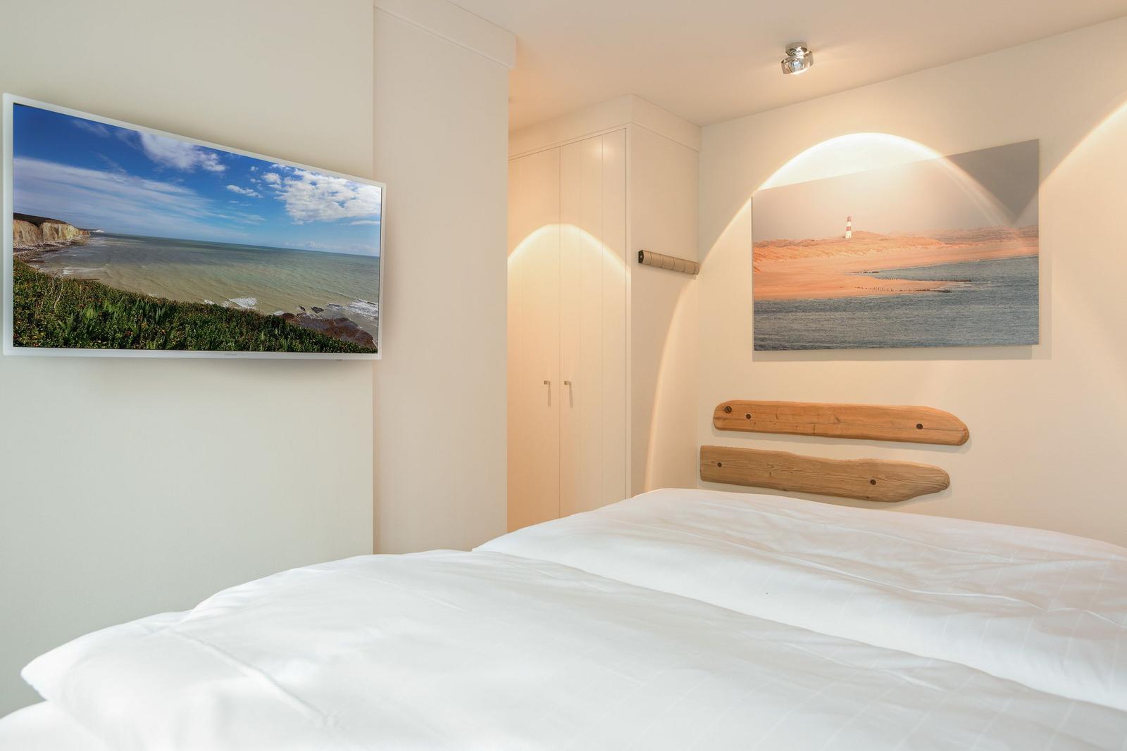 Bedroom with bed, wall art, and wardrobe.