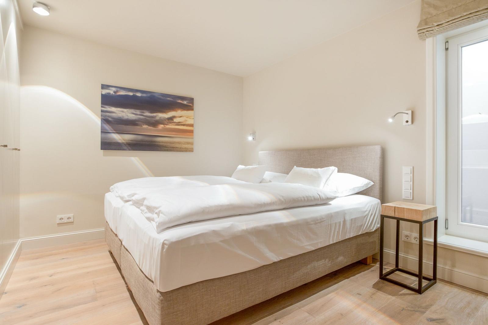 Bedroom with double bed, wall art, and window.