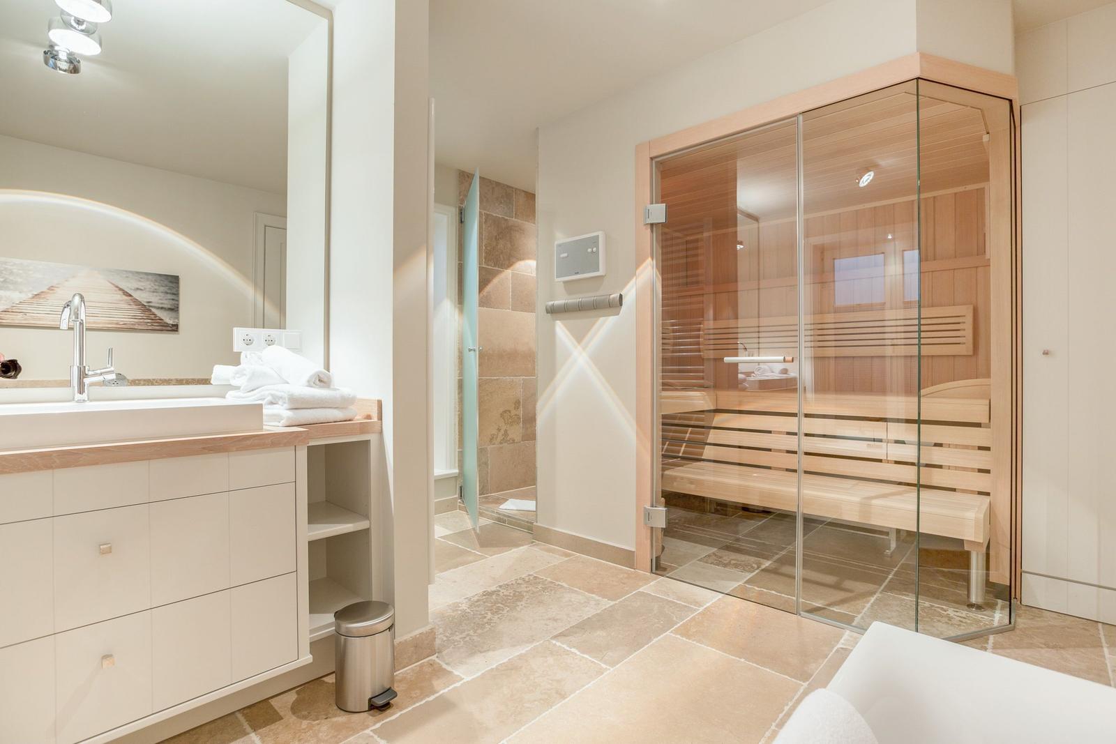 Bathroom with sauna, sink and shower.