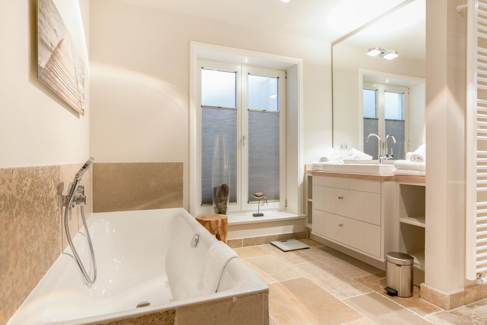 Bathroom with bathtub, sink and window