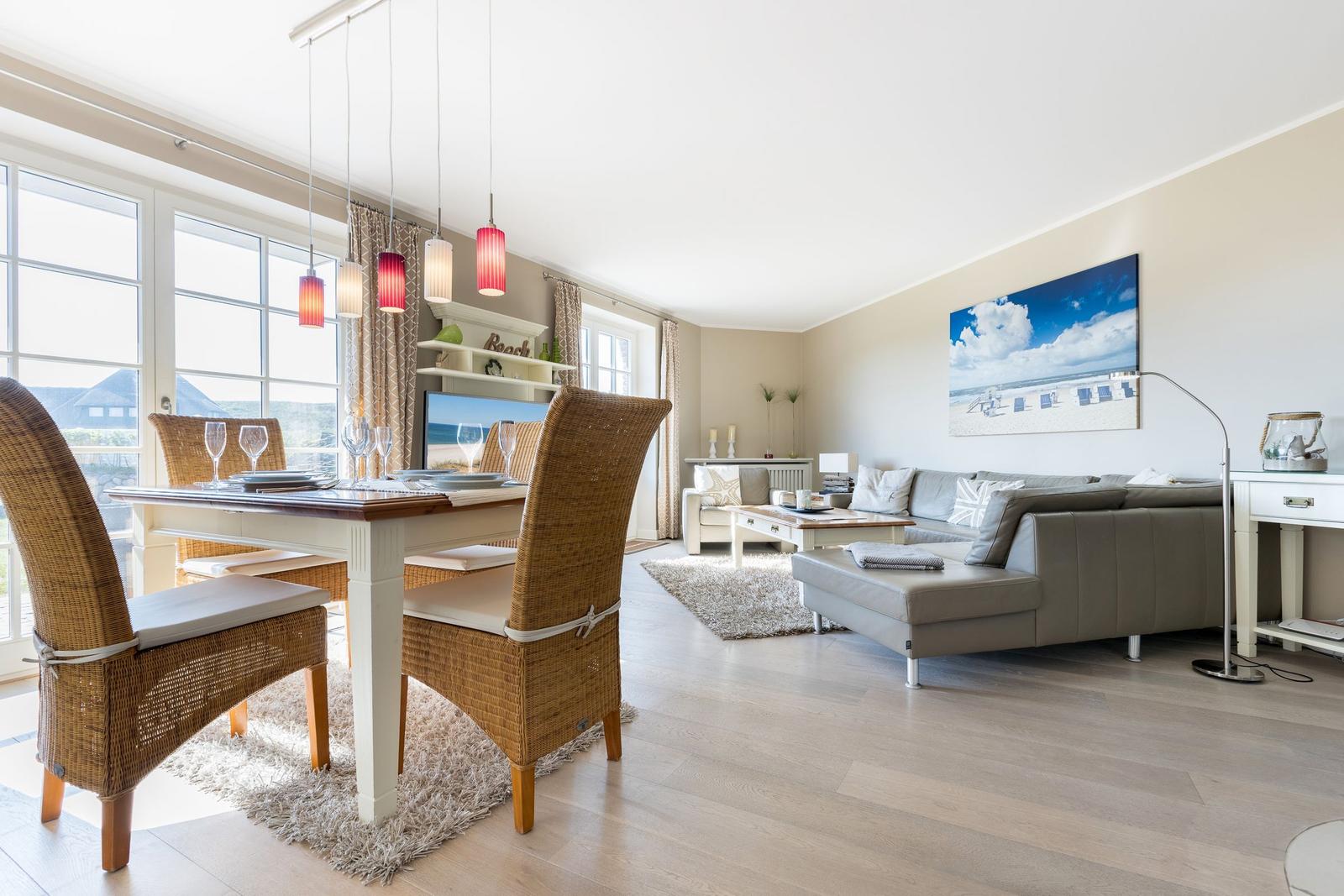 Esszimmer mit Esstisch und Stühlen. Wohnbereich mit Sofa und Fernseher.