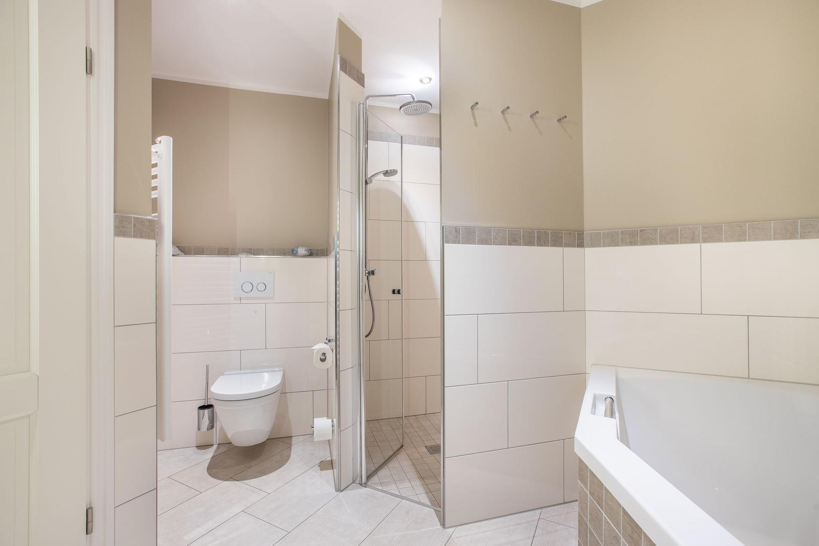 Badezimmer mit Dusche, Badewanne und Toilette.