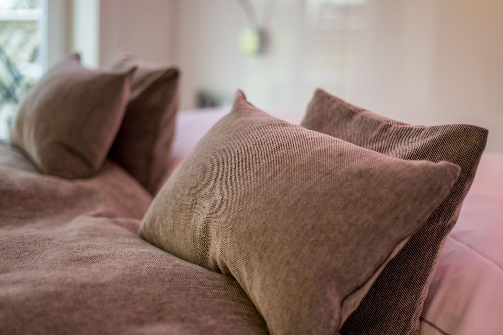 Headboard with pillows and bedding in brown tones