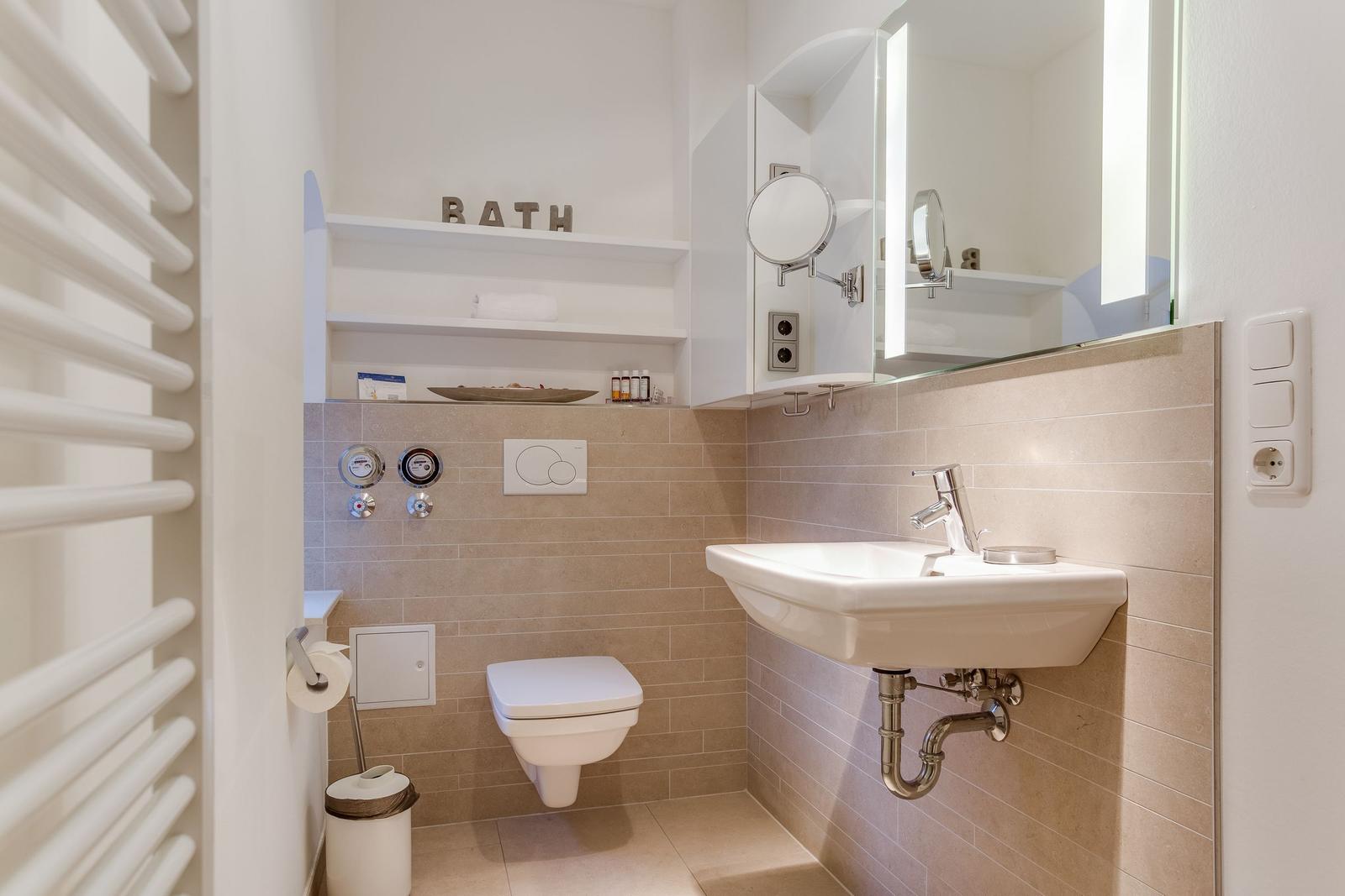 Bathroom with sink, toilet, and mirror cabinet.