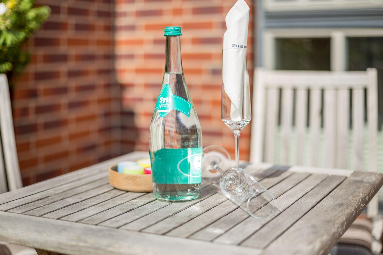 A water bottle and a glass with a napkin are on the table.
