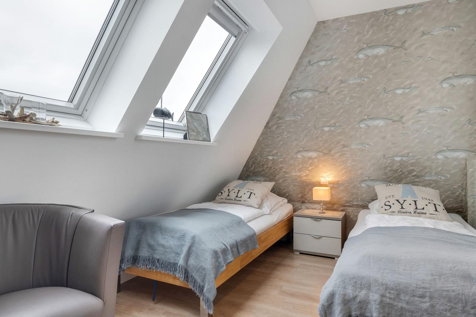 Zimmer mit zwei Betten, Fisch壁纸 und Dachfenstern.