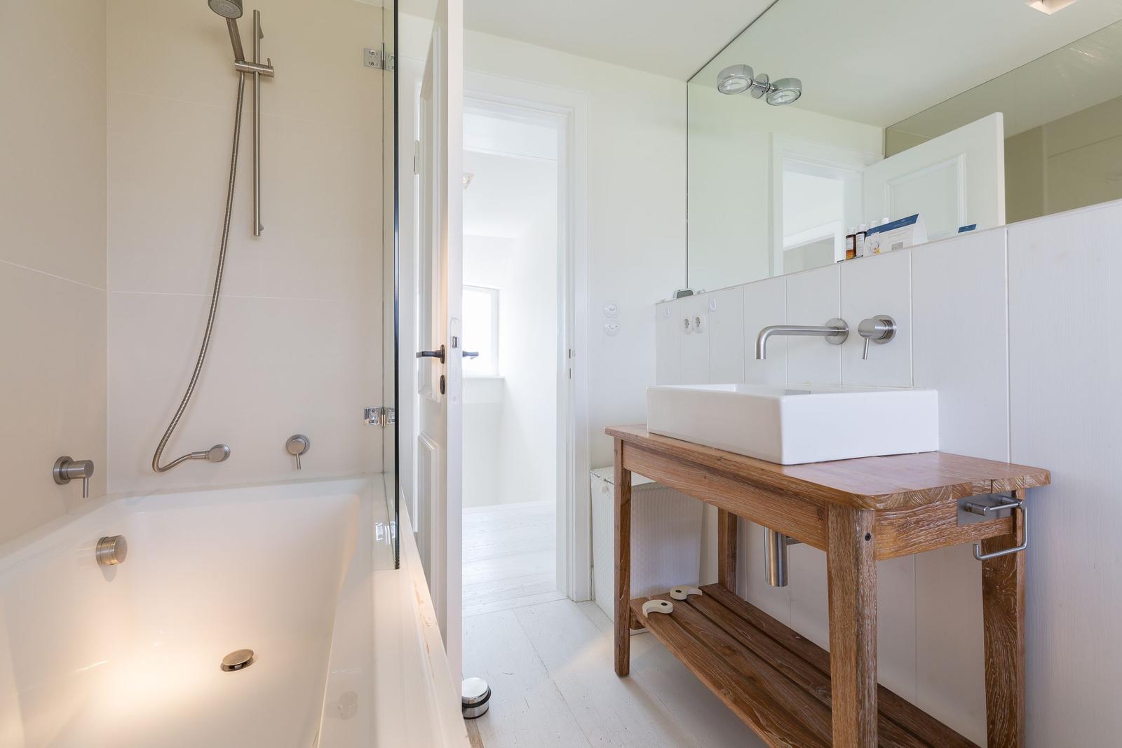 Bad mit Badewanne, Dusche und Waschtisch auf Holzkonsole