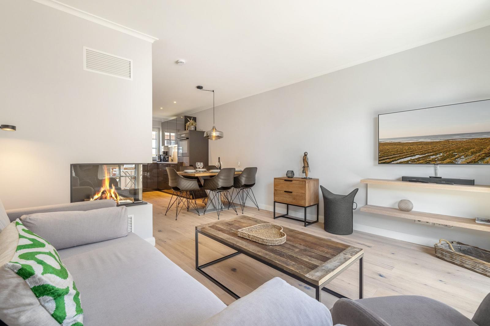 Wohnbereich mit Kamin, Esstisch und Fernseher an der Wand.