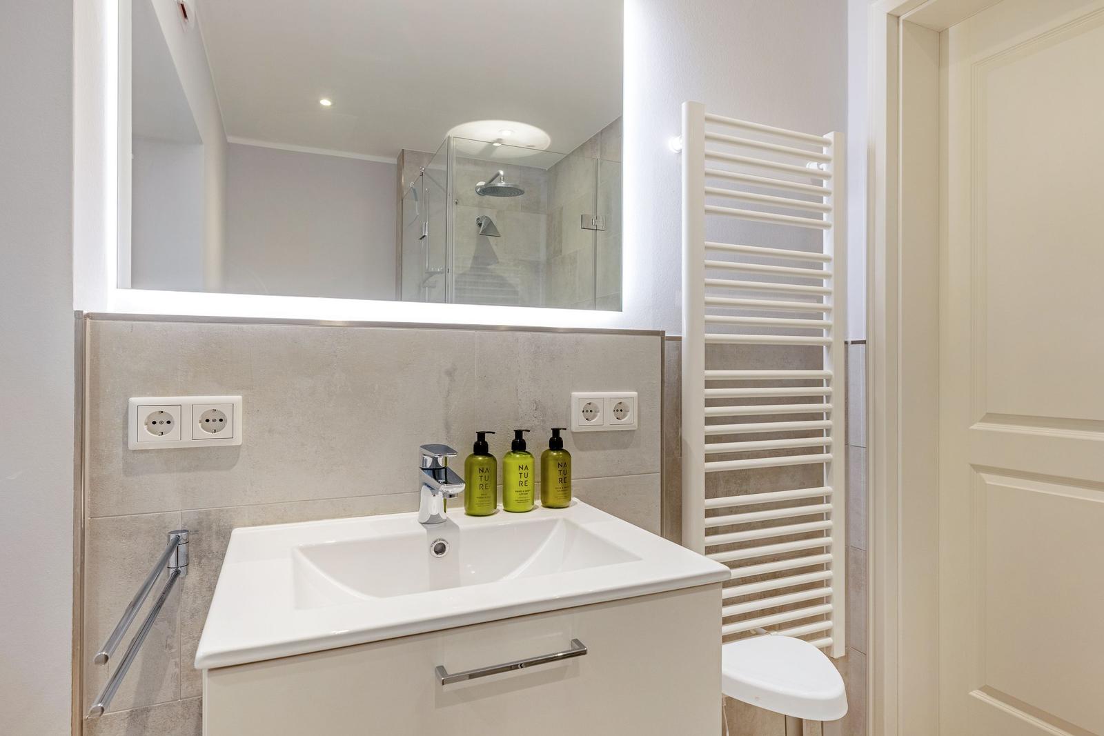 Bad mit Waschbecken, Spiegel und Dusche