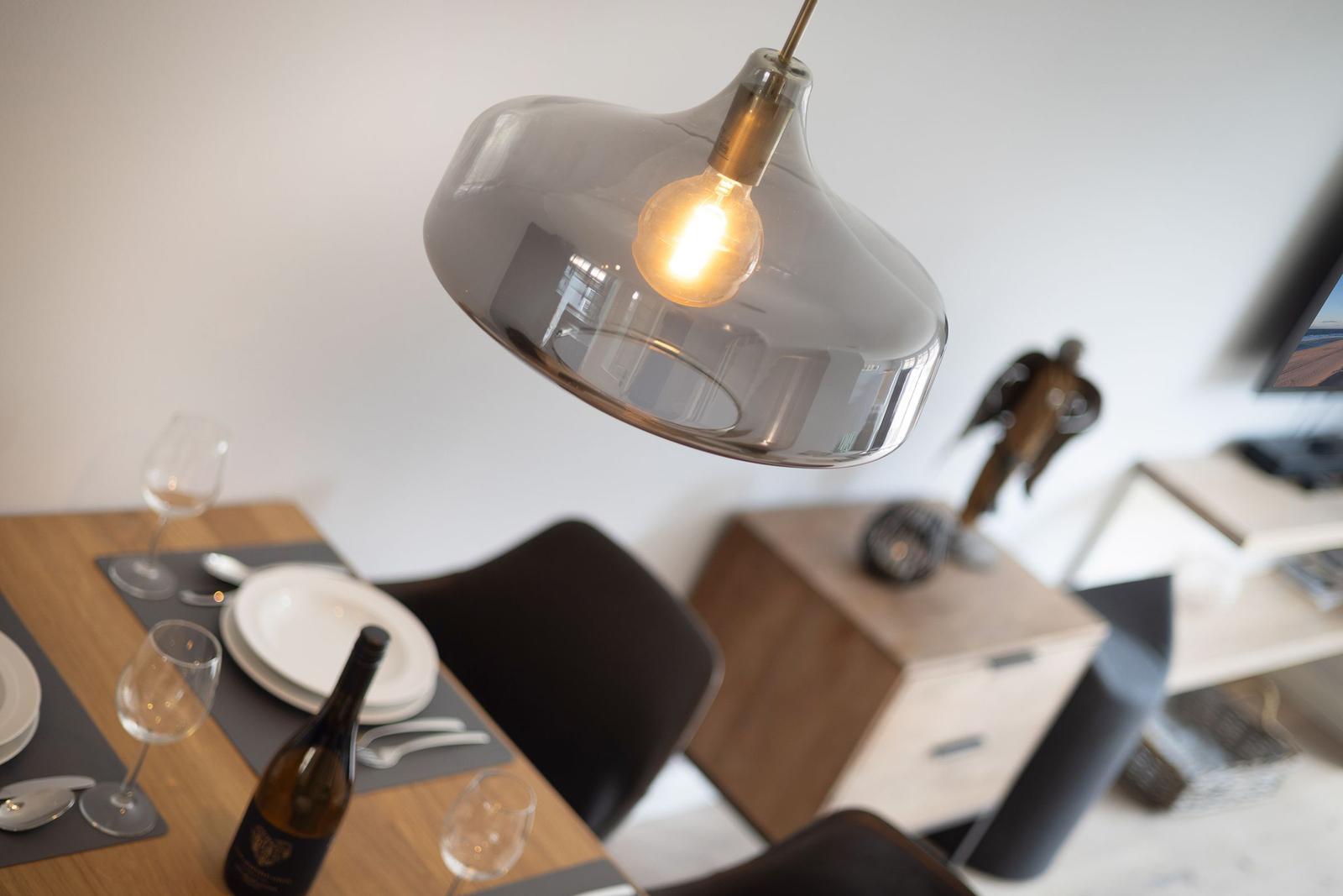 Esstisch mit Weinflasche und Lampe