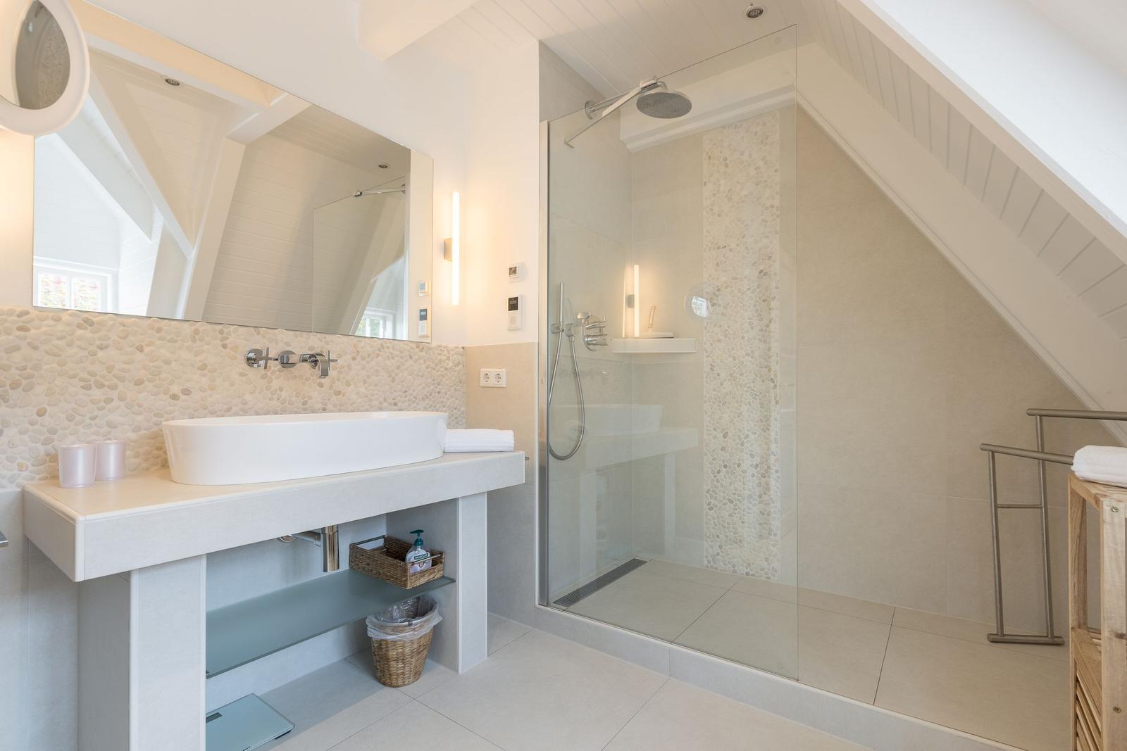 Badezimmer mit Dusche und Waschbecken unter Dachschräge