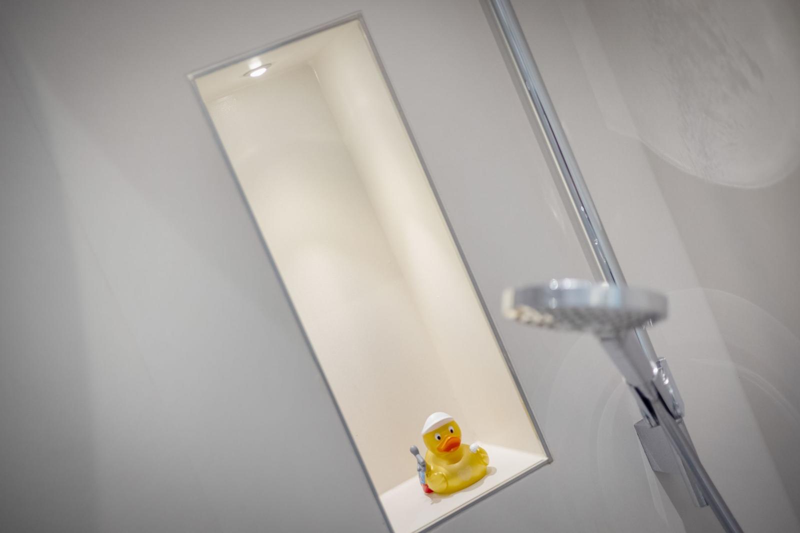Duschbereich mit gelber Ente und Duschkopf