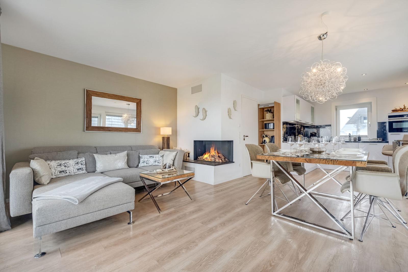 Wohn- und Essbereich mit Kamin, Sofa und Esstisch.