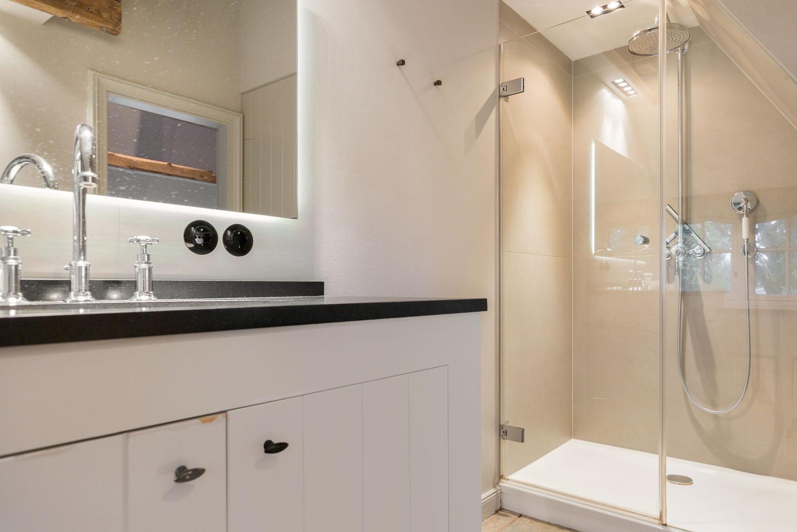 Bad mit Dusche und Waschbecken mit Spiegel