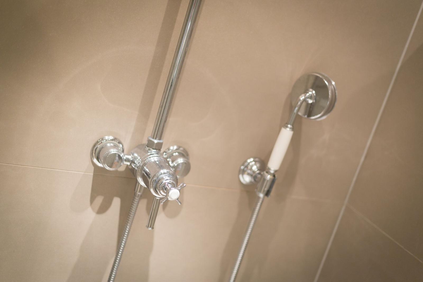 Duschkopf mit Handbrause und Duschstange an Wand montiert