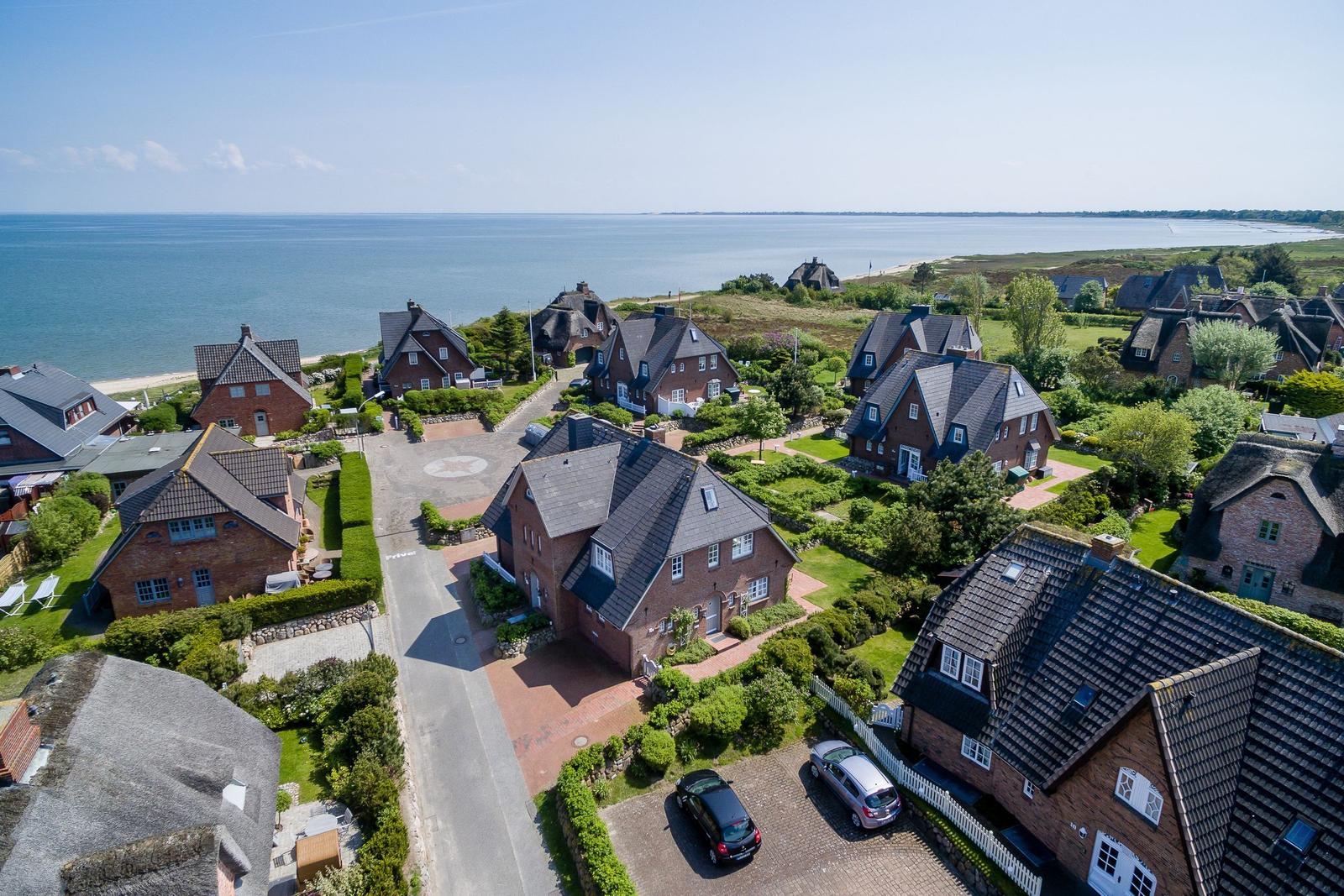 Houses with roofs and gardens by the sea