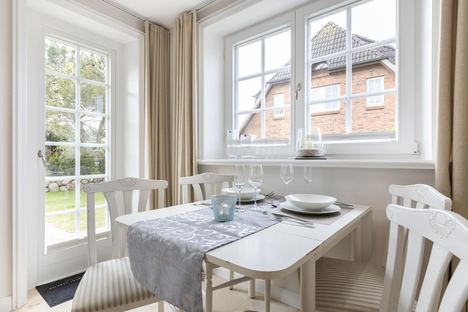 Dining table with chairs and windows to the garden