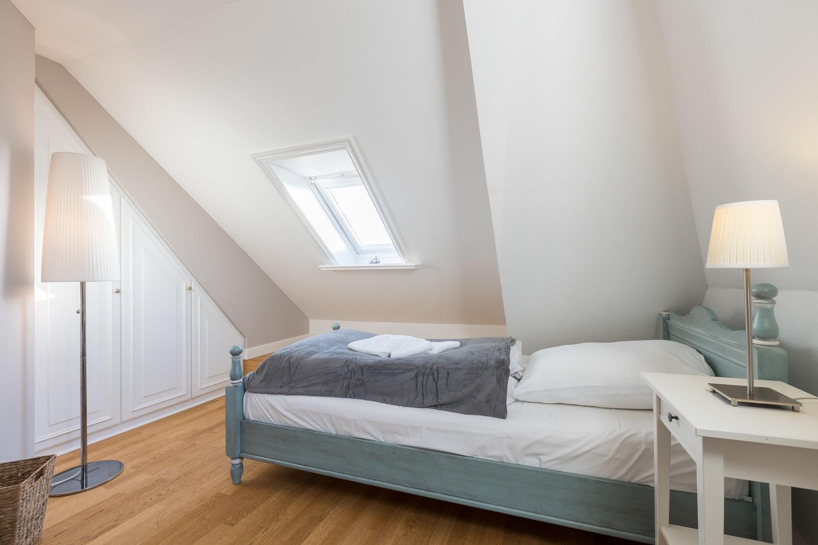 Bedroom with skylight, bed, and nightstand