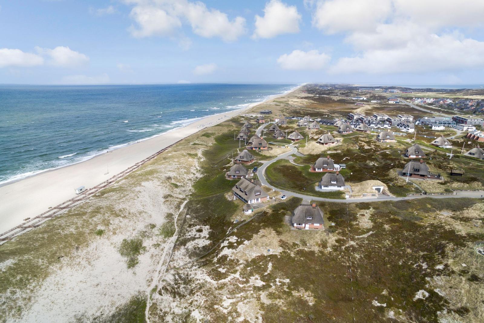 Dorf an der Küste mit Strand und Grasland