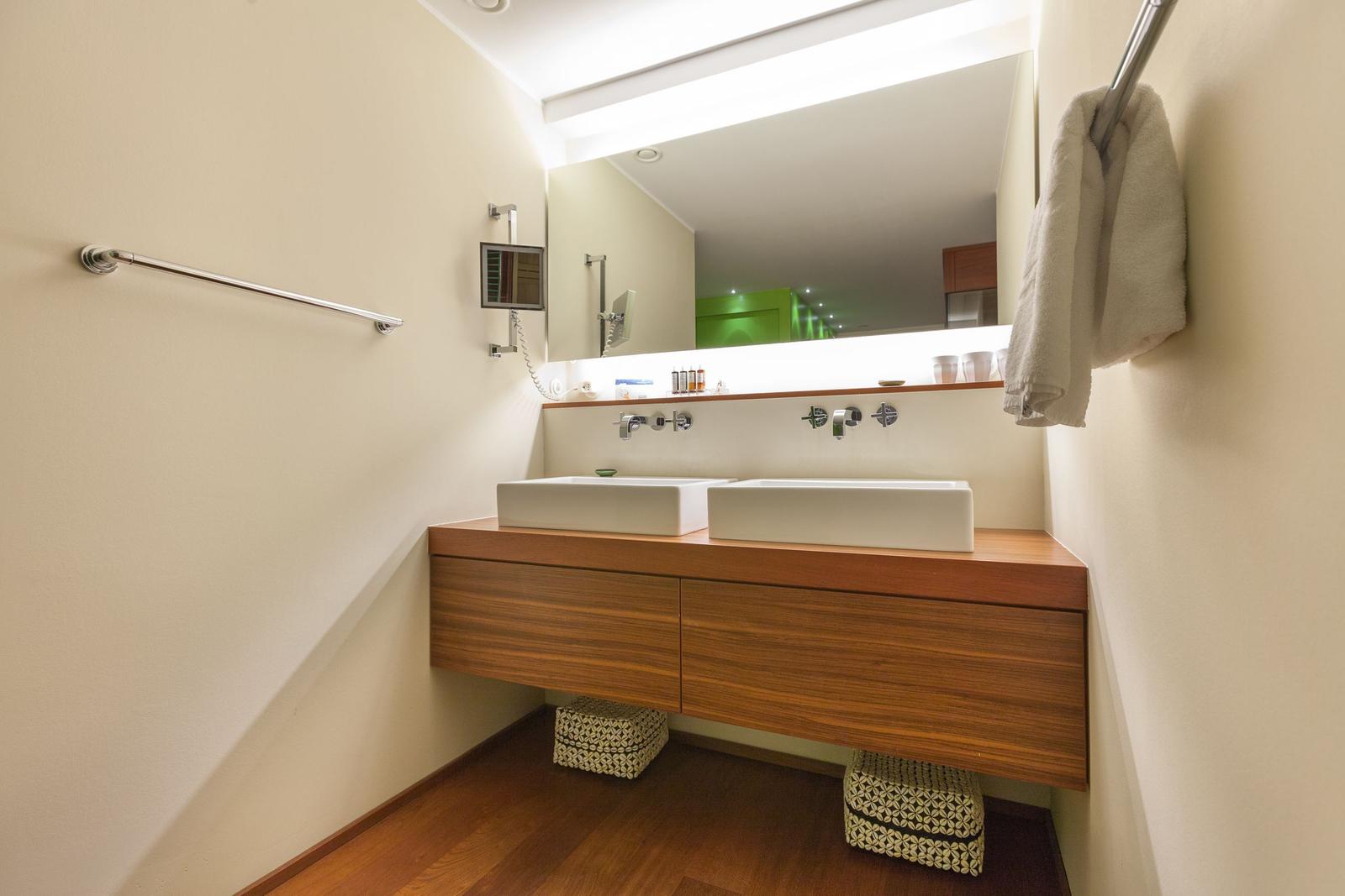 Badezimmer mit zwei Waschbecken, Spiegel und Handtuchhalter.