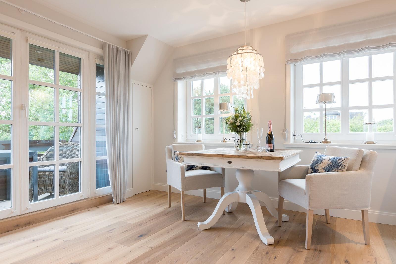 Esszimmer mit Tisch, Stühlen und Blick auf Terrasse.