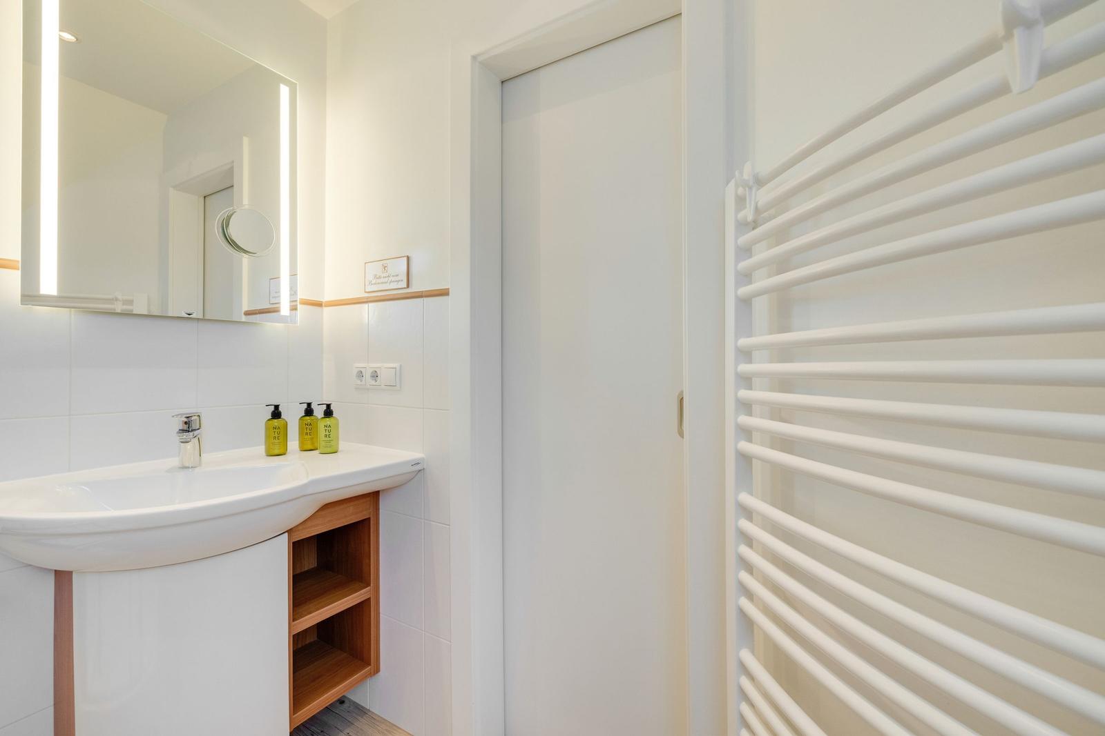 Bathroom with sink, mirror, and radiator