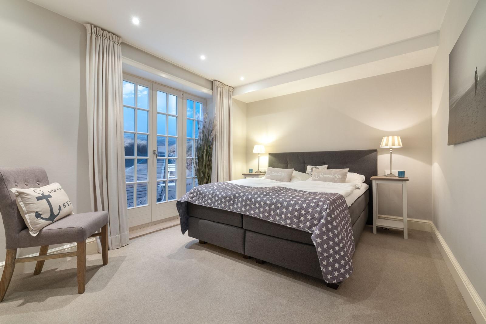 Schlafzimmer mit Doppelbett, Fenster und Sessel