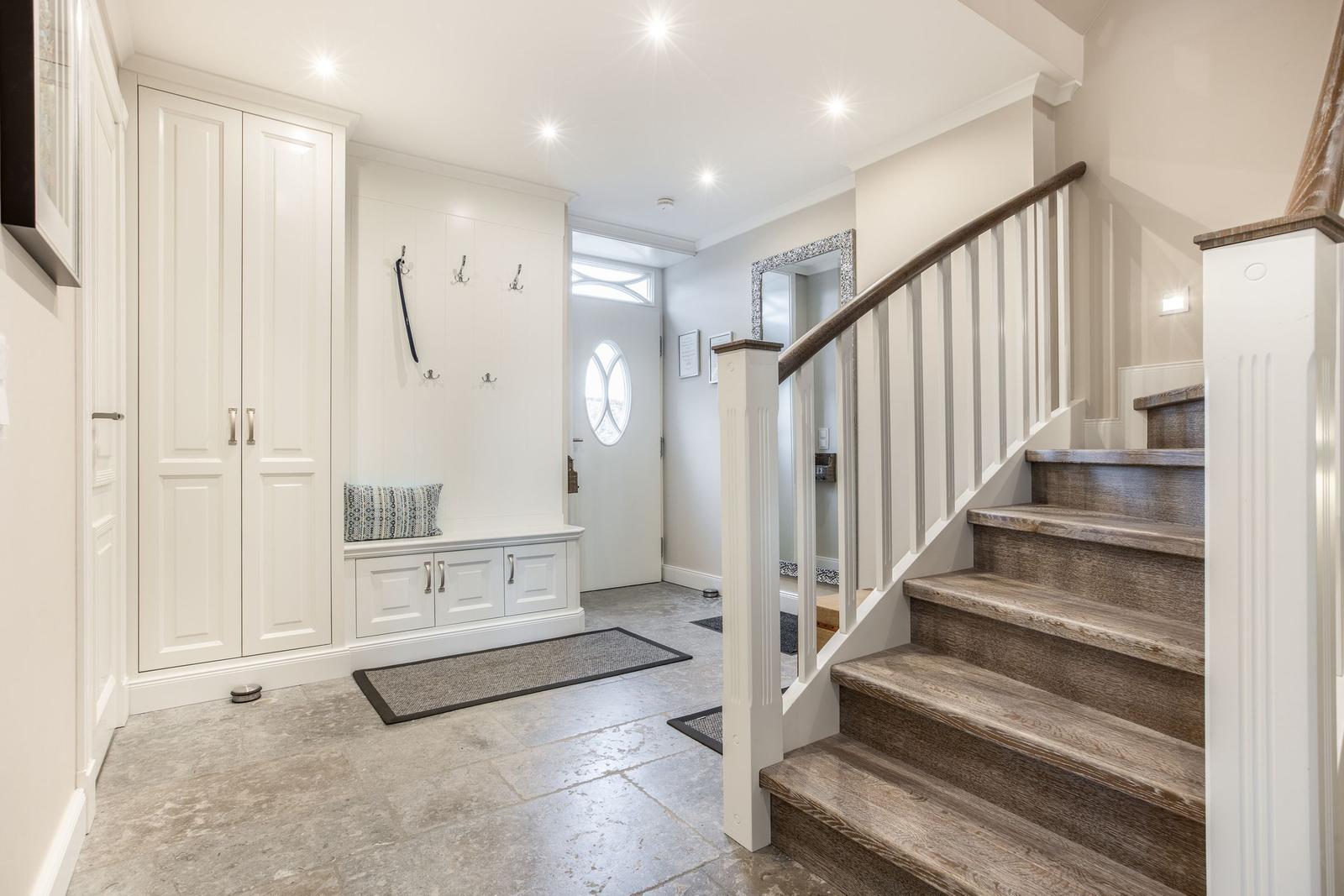 Eingangsbereich mit Garderobe, Sitzbank und Treppe.