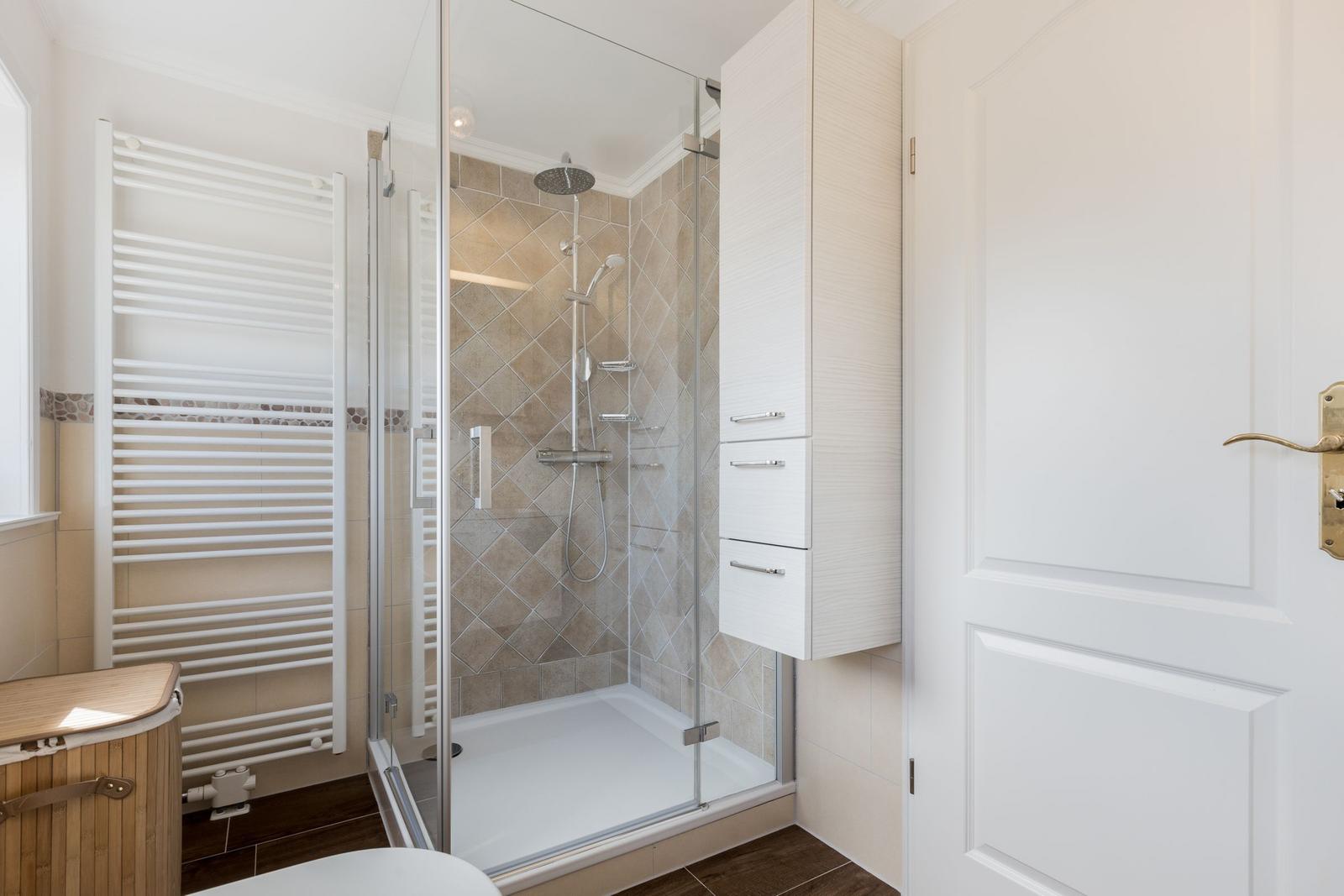 Dusche mit Glaswand, Heizung und Schrank