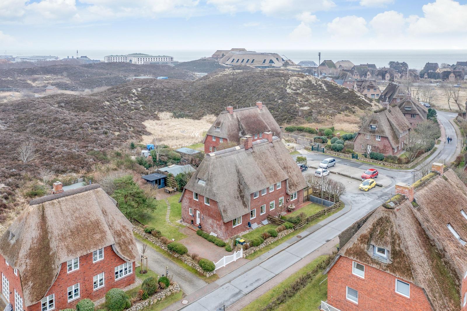 Village with thatched houses and view of the North Sea