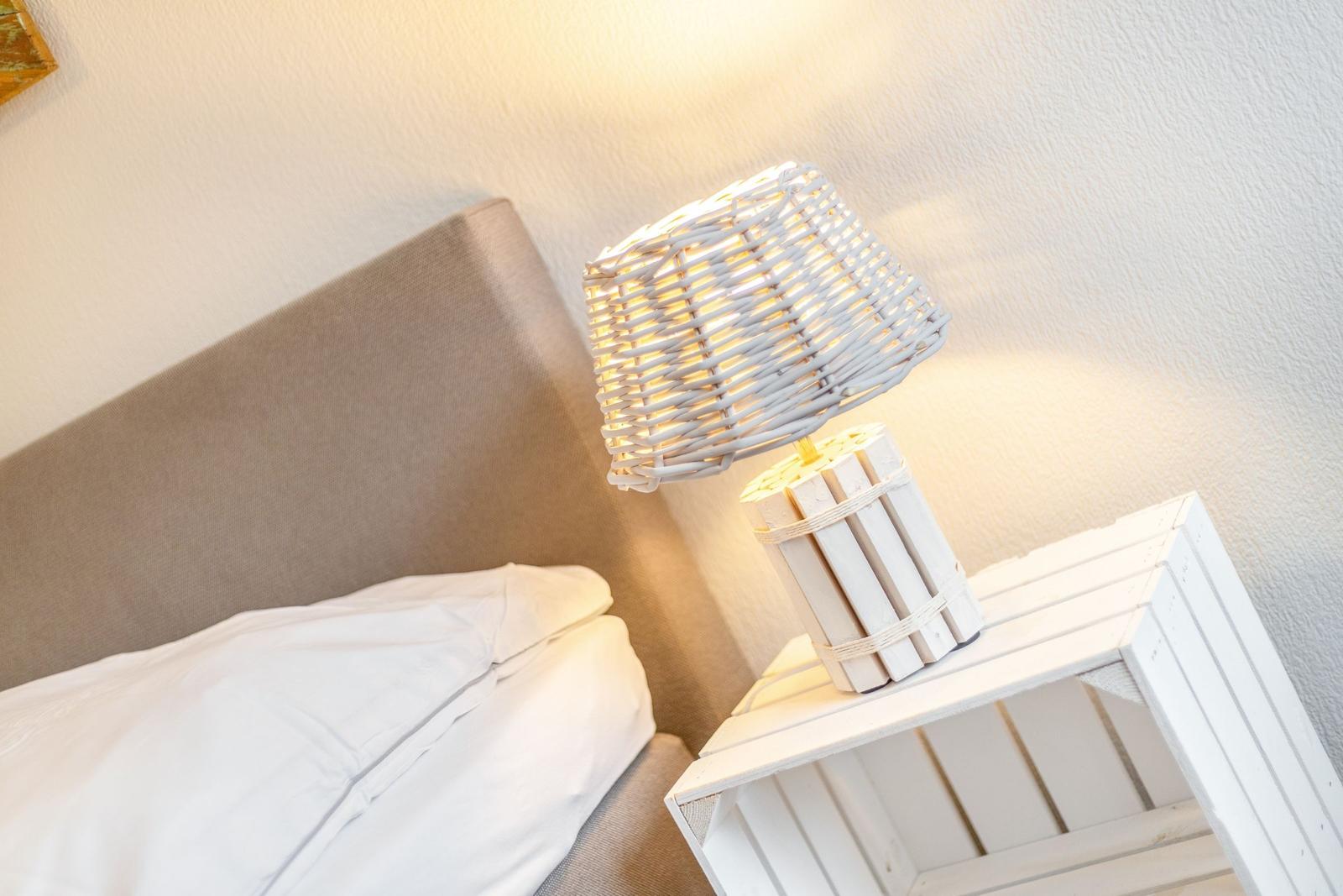 Bedroom with bed, nightstand, and lamp.